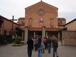 A group of individuals moves towards the entrance of The Sanctuary of the Leopoldo Mandic compound.