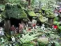 Small Inari statues and moss covered miniature shrines