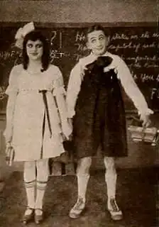 Still from the American comedy short film School Days (1920) with Larry Semon and Lucille Carlisle, on page 3869 of the May 1, 1920 Motion Picture News.