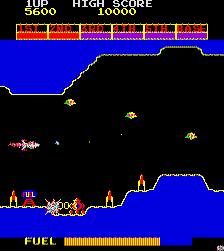 A screen shot of Scramble, in which a spaceship controlled by the player is shooting at incoming enemies to the right. At the top of the screen are the current score and high score. Below the highscore is a bar depicting progress through the game. At the bottom is a status bar displaying fuel capacity.
