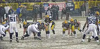 Packers and Seahawks players lining up to run a play in snowy conditions