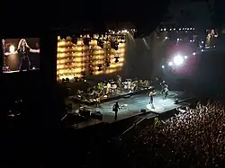 Shakira doing a performance of her song while her fans sing with her