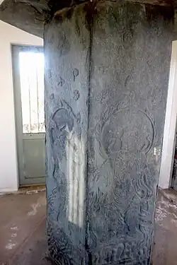 Stone column with reliefs of deities.