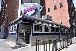 A blue and silver restaurant building, with a large "South Street Diner Open 24/7" sign on the roof