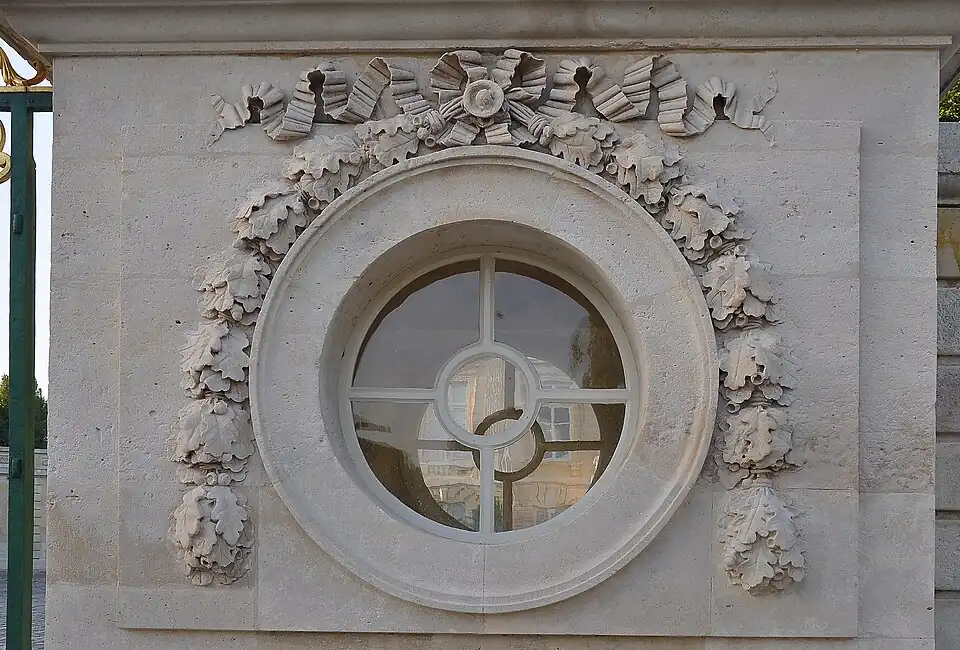 Oculus of the Petit Trianon (Versailles, France), with a ribbon at the top and two festoon-derived hanging ornaments
