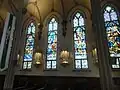 View of stained glass windows in north aisle.