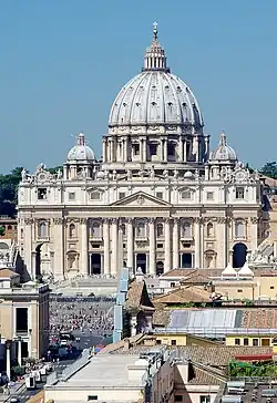 Photo. The façade is wide and has a row of huge columns rising from the basement to support the cornice. The ribbed, ovoid dome is surmounted by a lantern topped with ball and cross. Its drum is framed by two very much smaller domes.