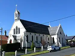 A large white catholic church building with a gray roof