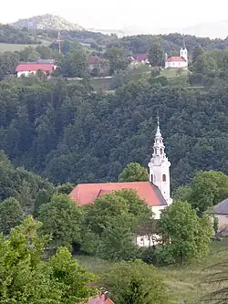 Our Lady Comforter of the Afflicted Church in Stopiče. In the background, Gornja Težka Voda.