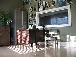 Interior photo of the Sun Record Company front office, with period furnishings and pictures of recording artists on the wall.