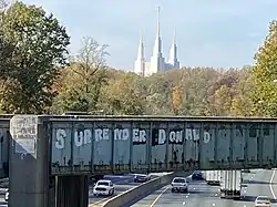 Washington LDS Temple as seen from Interstate 495. The graffito was updated to say Surrender Donald
