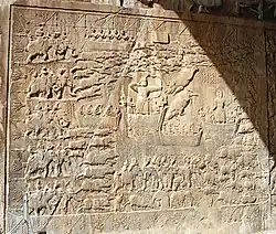 Rock relief on the left side panel, depicting a boar hunt.