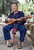 A Thai Lue musician plays in the garden of Wat Nong Bua, Tha Wang Pha District, Thailand.