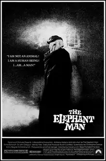 In black and white, a man is standing behind a building wearing a hood (with one eyehole) and hat to cover his face, with the film's title appearing below the figure. The film's tagline reads "I am not an animal! I am a human being! I...am...a man!"