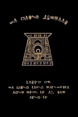 Black cover with gold engravings in a made up orthographic system. In the middle, there is a symbol with an ankh
