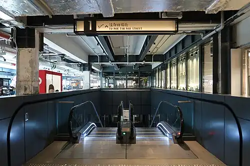 Engraved signage in front of the escalator.