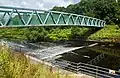 The_River_Mersey_passes_over_a_weir_under_a_footbridge_-_geograph.org.uk_-_4066656