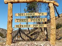 Three Points welcome sign and fire-burned trees