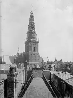 A black and white image of an ornate church tower taken from a rooftop