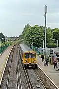 A Merseyrail class 507 waits at the station, viewed from the footbridge.