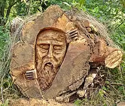 Carving of a face into a log