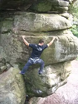 A rock climber scaling a sandstone crag.