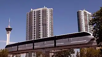 Ground-level view of a 45-story tower at night; the building, which is lit up, has a rectangular cross section and a white facade.