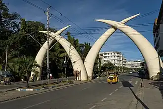 Picture of the four white tusks, in two pairs each forming an arch, over a dual carriageway