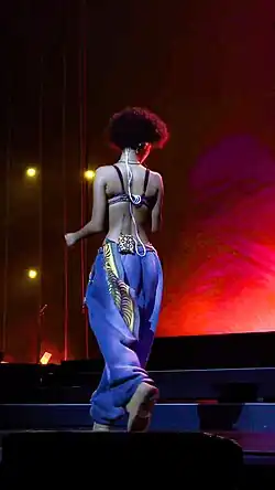 Tyla in blue baggy jeans performing on stage during her homecoming tour in South Africa.
