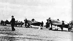 Polish Air Force Academy airfield with four planes and a number of men around them