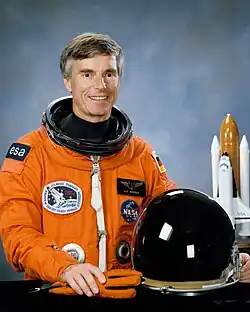Ulf Merbold wearing an orange spacesuit