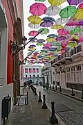 Calle de la Fortaleza leading to the palace with a canopy of multicolored umbrellas