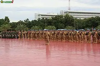 A formation military personnel in three ranks on the red parade ground at the headquarters of the Indonesian military