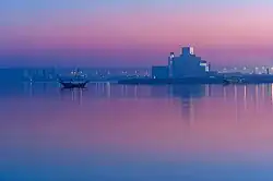 View of the Persian Gulf and the Museum of Islamic Art in Qatar at dusk