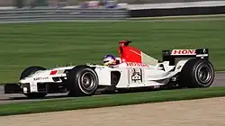 Jacques Villeneuve driving the BAR 005 with non-tobacco livery replaced with bar code and F1 cars at the 2003 United States Grand Prix.