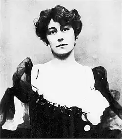 head and torso of young white woman with dark hair, in Victorian evening dress, looking towards the camera