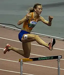 Photo of Femke Bol while jumping over a hurdle