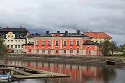 A three-storey, red-orange building on the waterfront