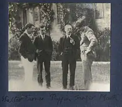 Monochrome photograph of Anthony Asquith and friends standing in a garden