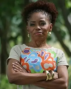 Wanda Chase stands with her arms crossed, facing the camera