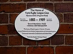a white oval plaque on a brick wall