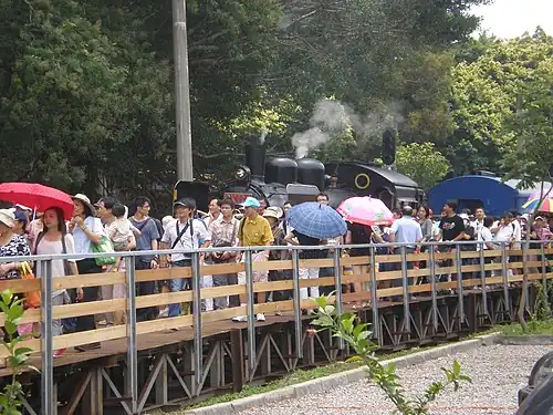 Yutengping railway station's wooden platform with steam locomotive number CK124 in the background.