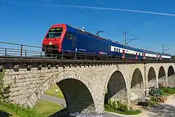 Refurbished Re 450 locomotive and coaches (DPZplus) on the Eglisau railway bridge in 2016, with low-loader coach behind the locomotive